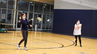Two students throw a frisbee in the wellness center