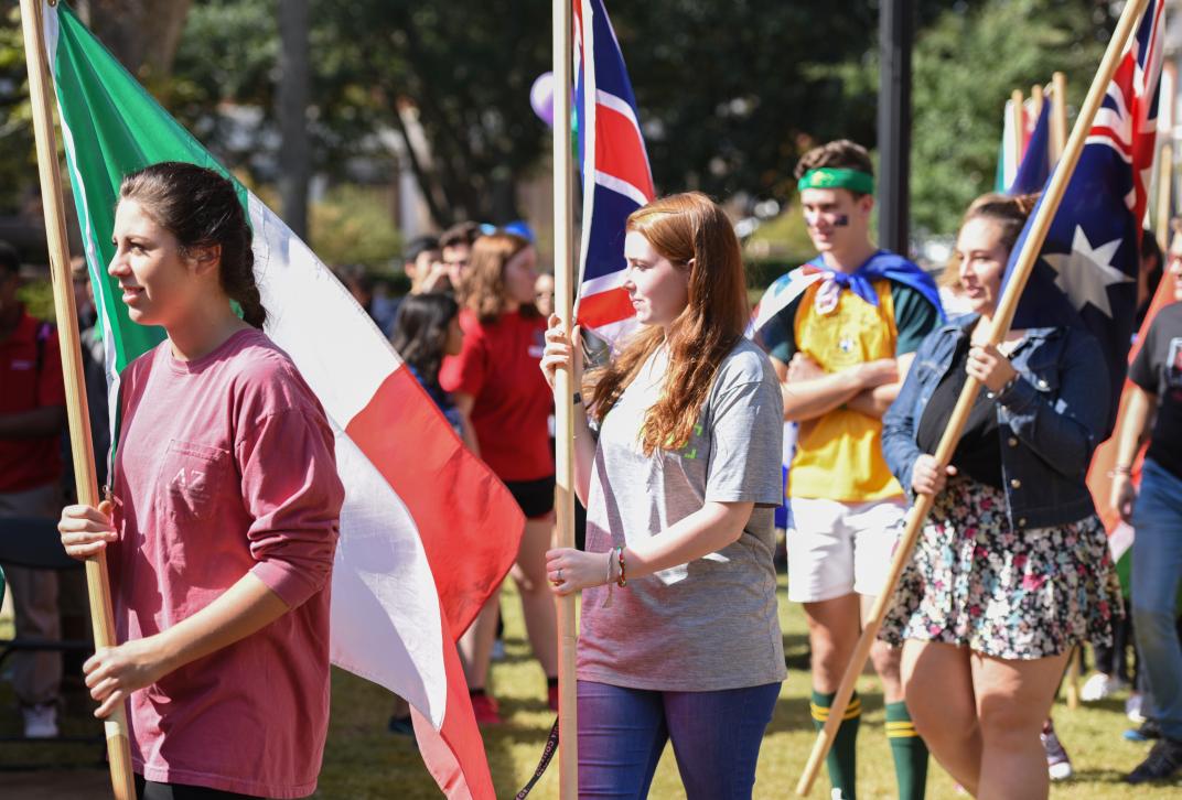 Students carry their country's flags at the international parade