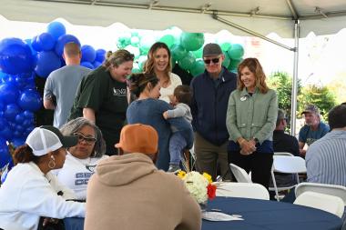 Alumni gather around the tent at Deep Roots to catch up with each other