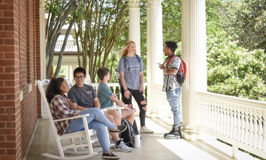 Students gathered on the front porch rocking chairs of Atkinson Hall